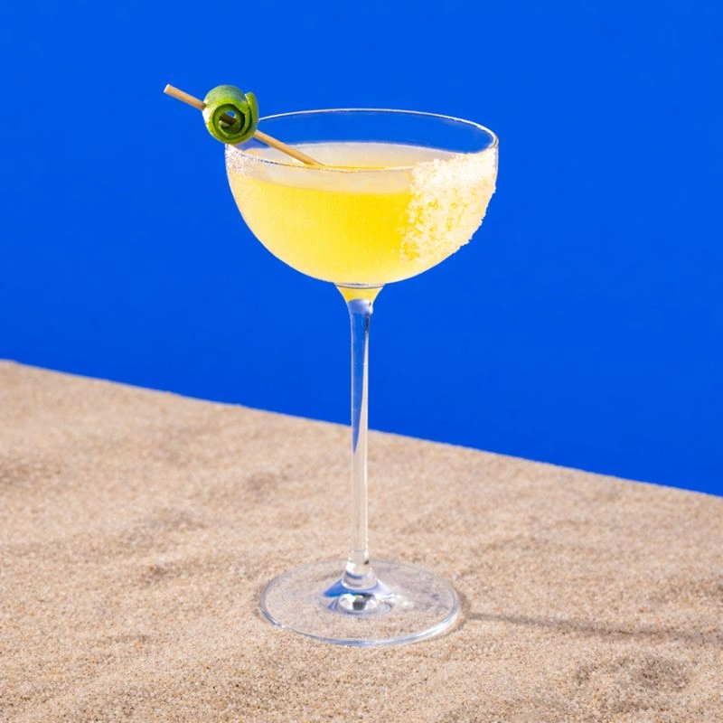 Cocktail à base de tequila et de mix à margarita sur fond bleu royal.