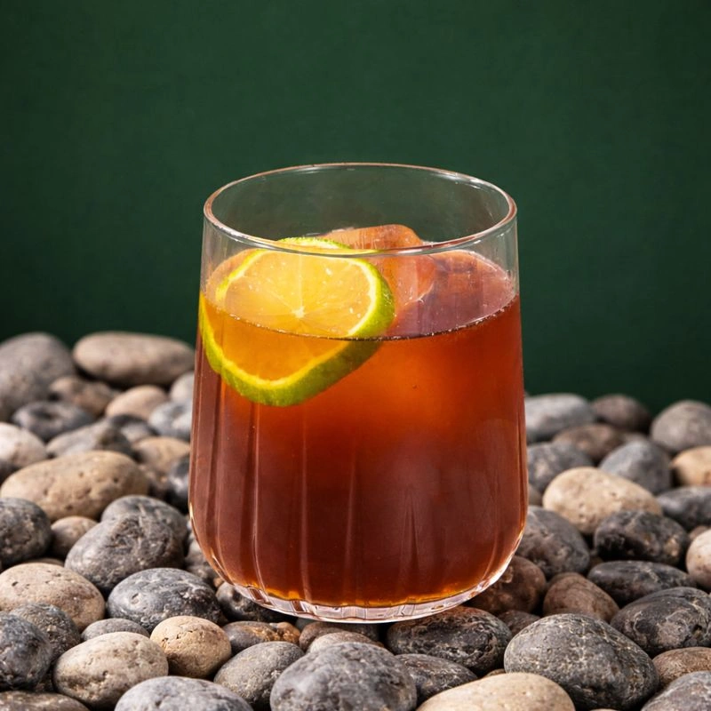 Cocktail à base de rhum ambré, de sirop de lime et de cola sur fond lilas.