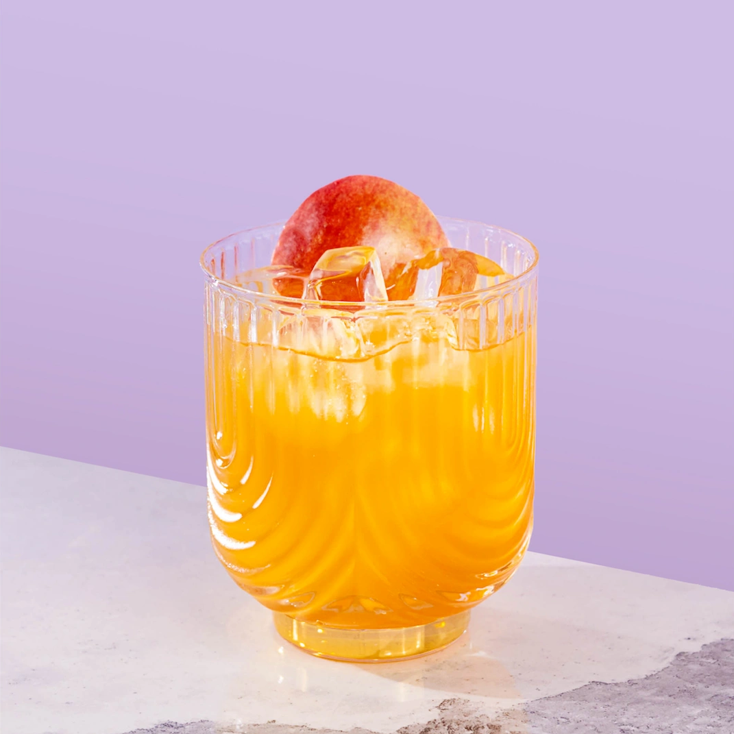 Cocktail made with brandy, ginger syrup, maple syrup, apples and lemon on a lilac background.