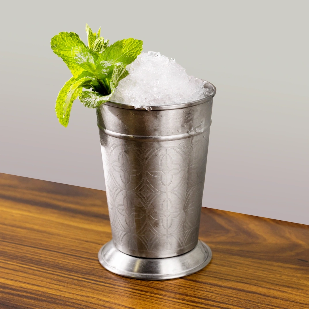 Cocktail à base de bourbon et de mix à mojito sur fond gris.