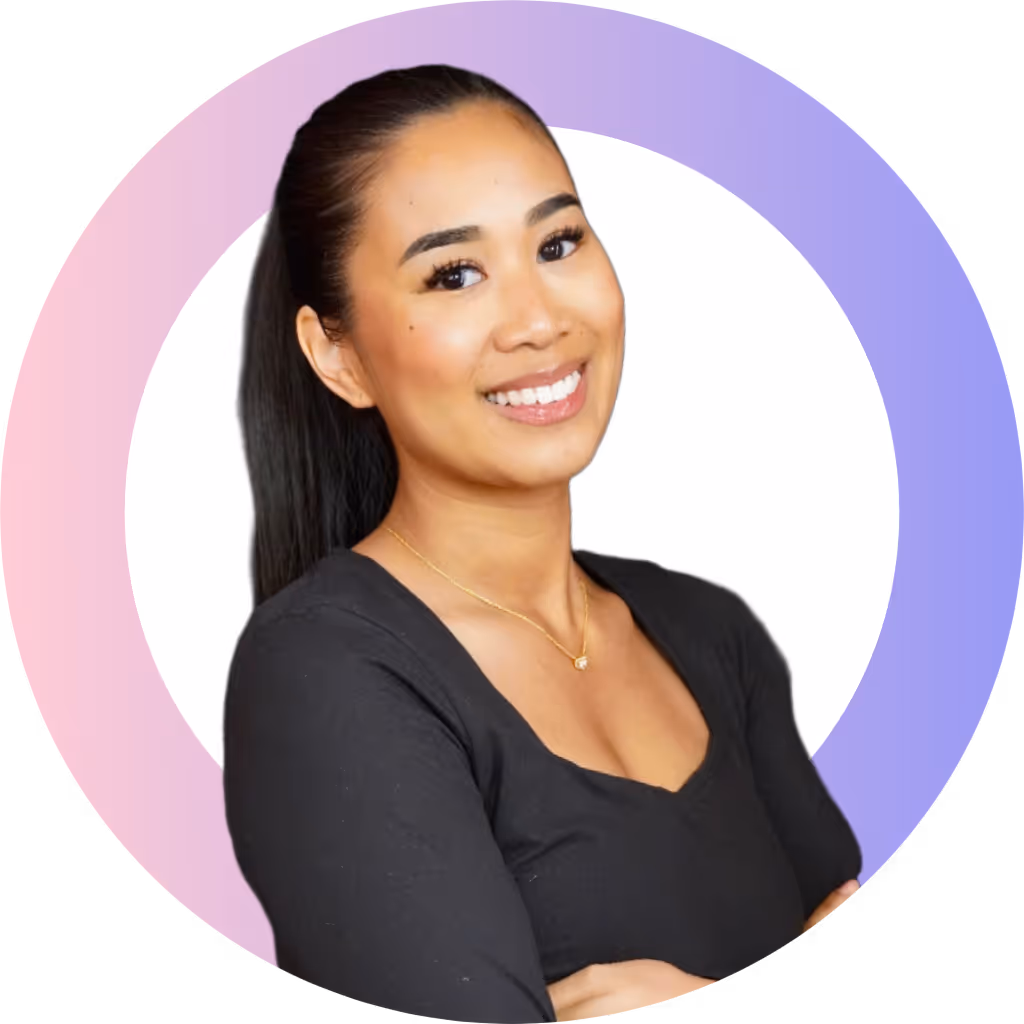 Portrait d'une femme souriante aux cheveux attachés en queue de cheval portant un haut noir et un collier doré.