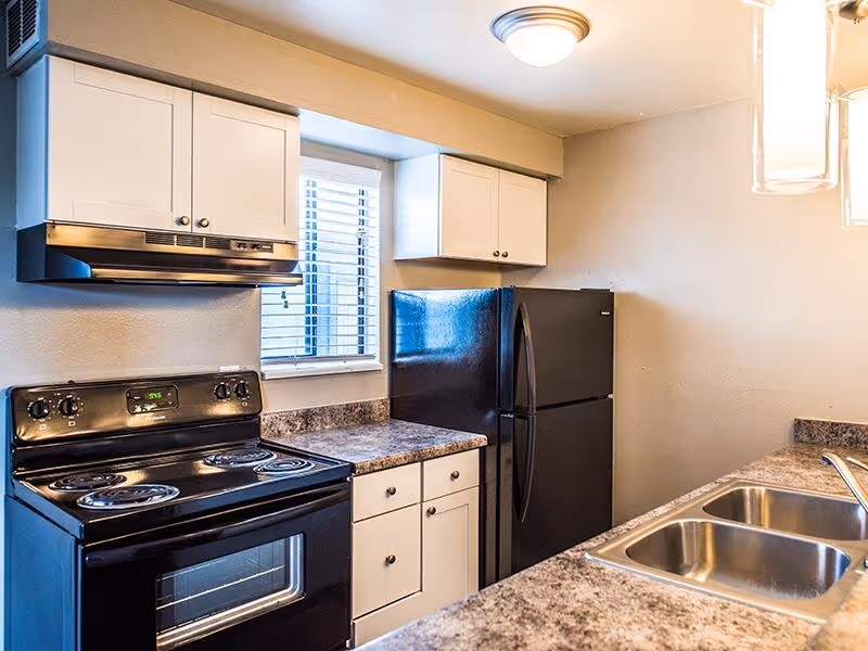 Kitchen with white cabinets and black appliances