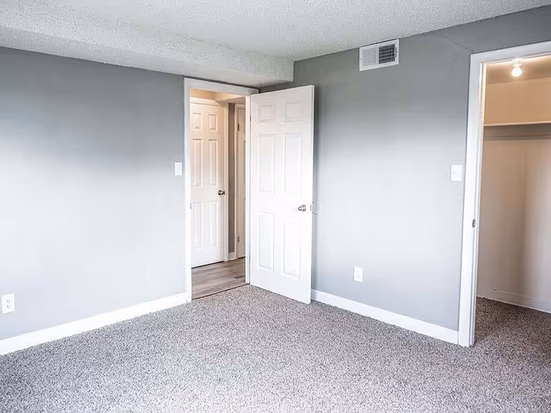 Empty room with entrances to closet and hallway