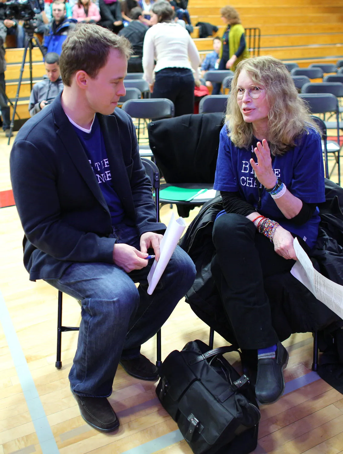a man and a woman sitting on chairs in a gym