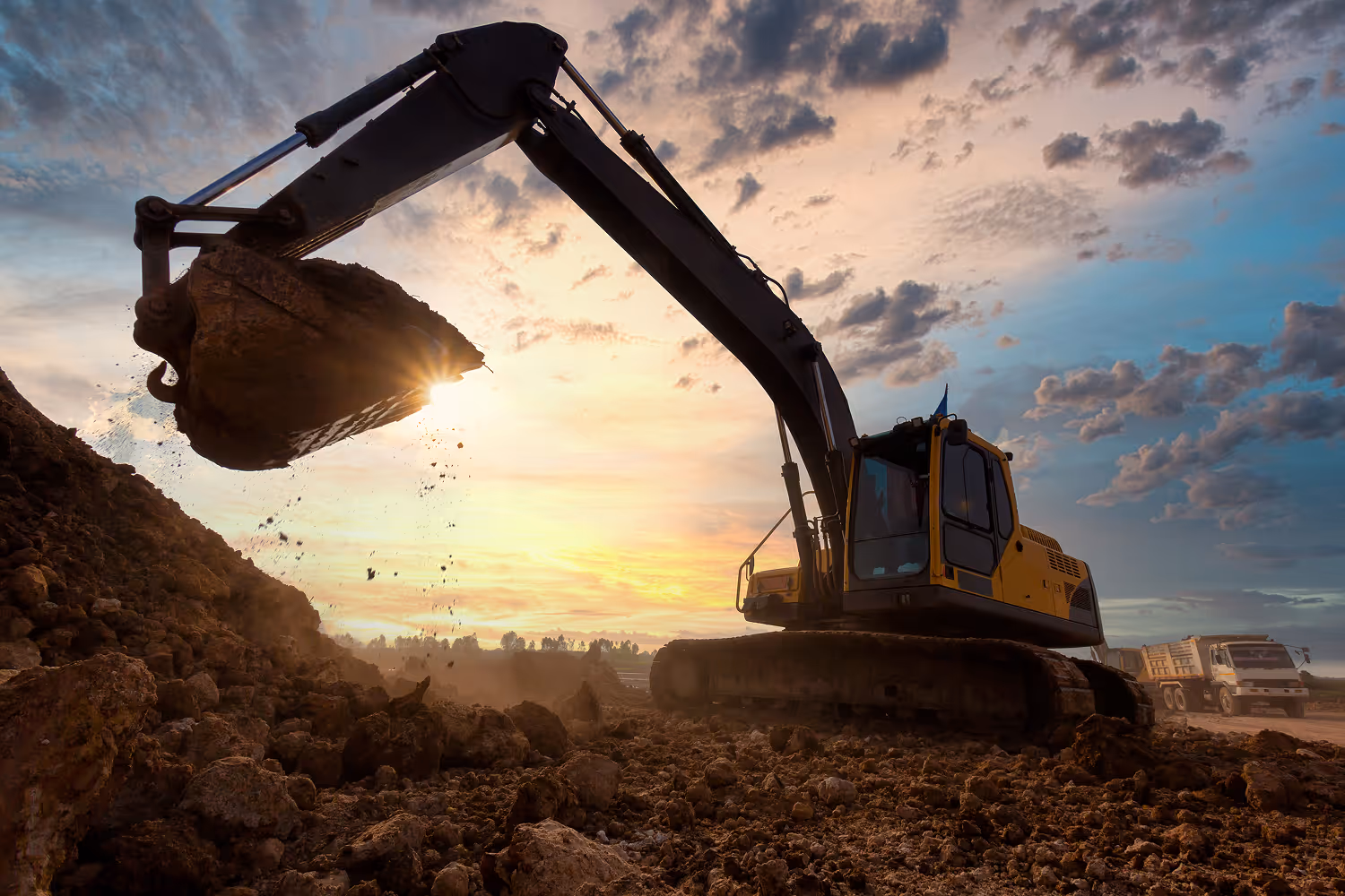 Construction excavator lifting up a pile of dirt.