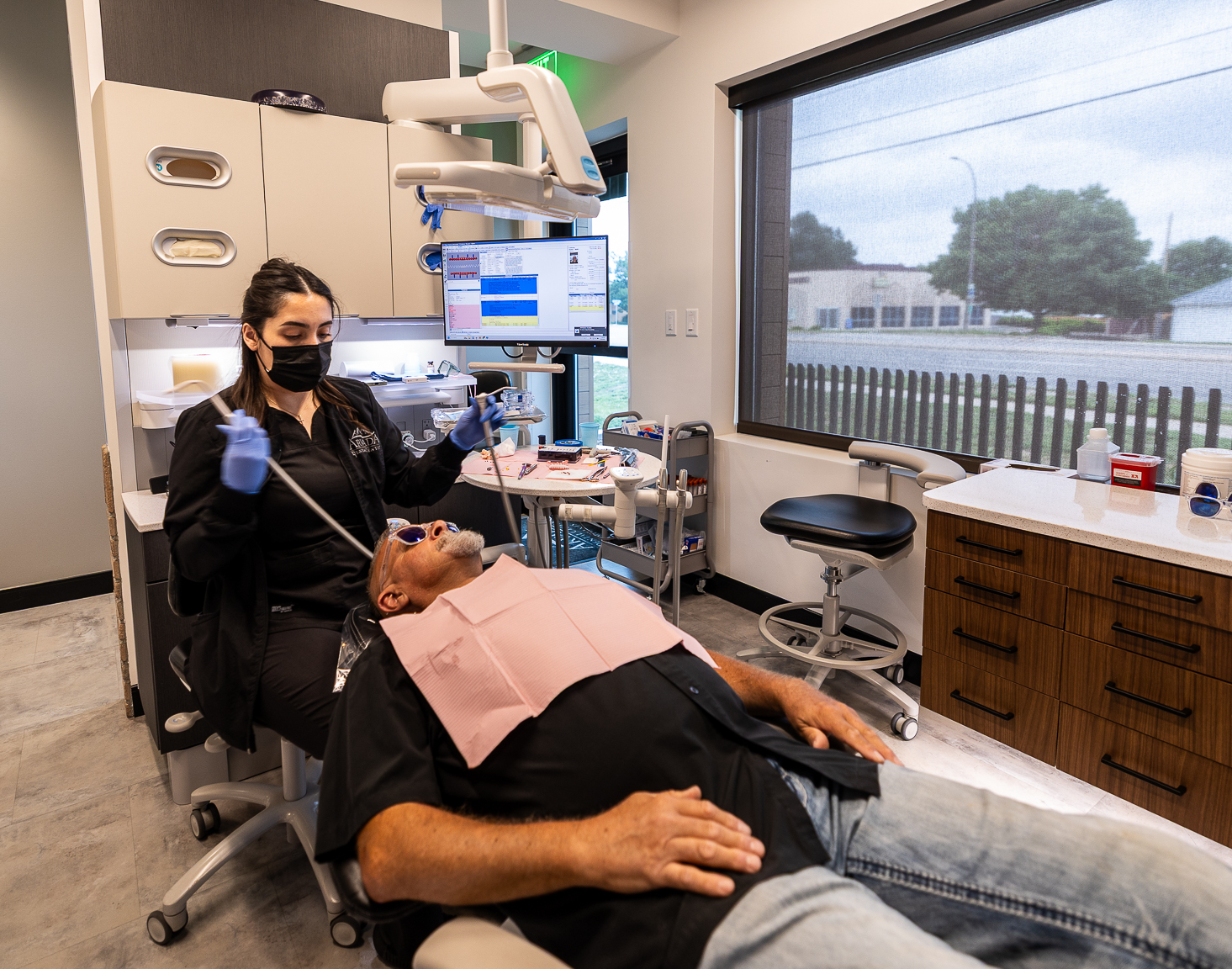 Dental professional treating a patient in a modern operatory