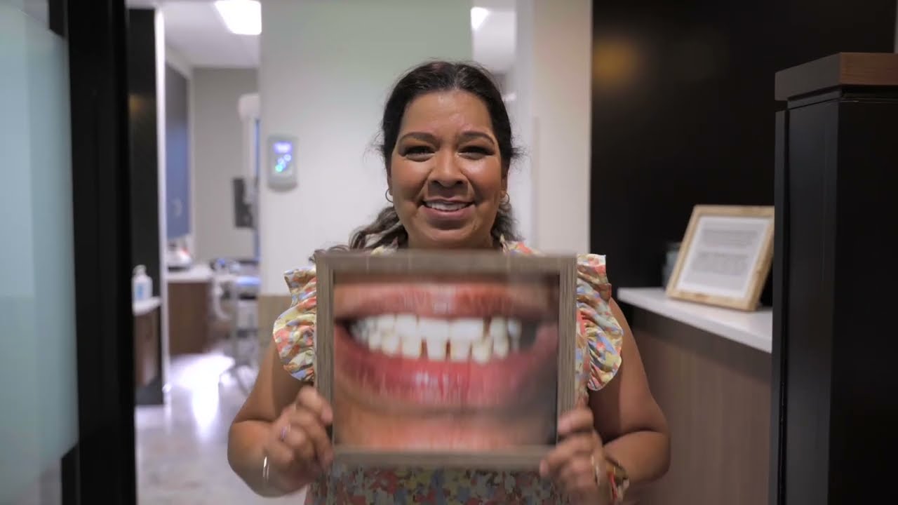 Anna holding a photo of her smile before treatment