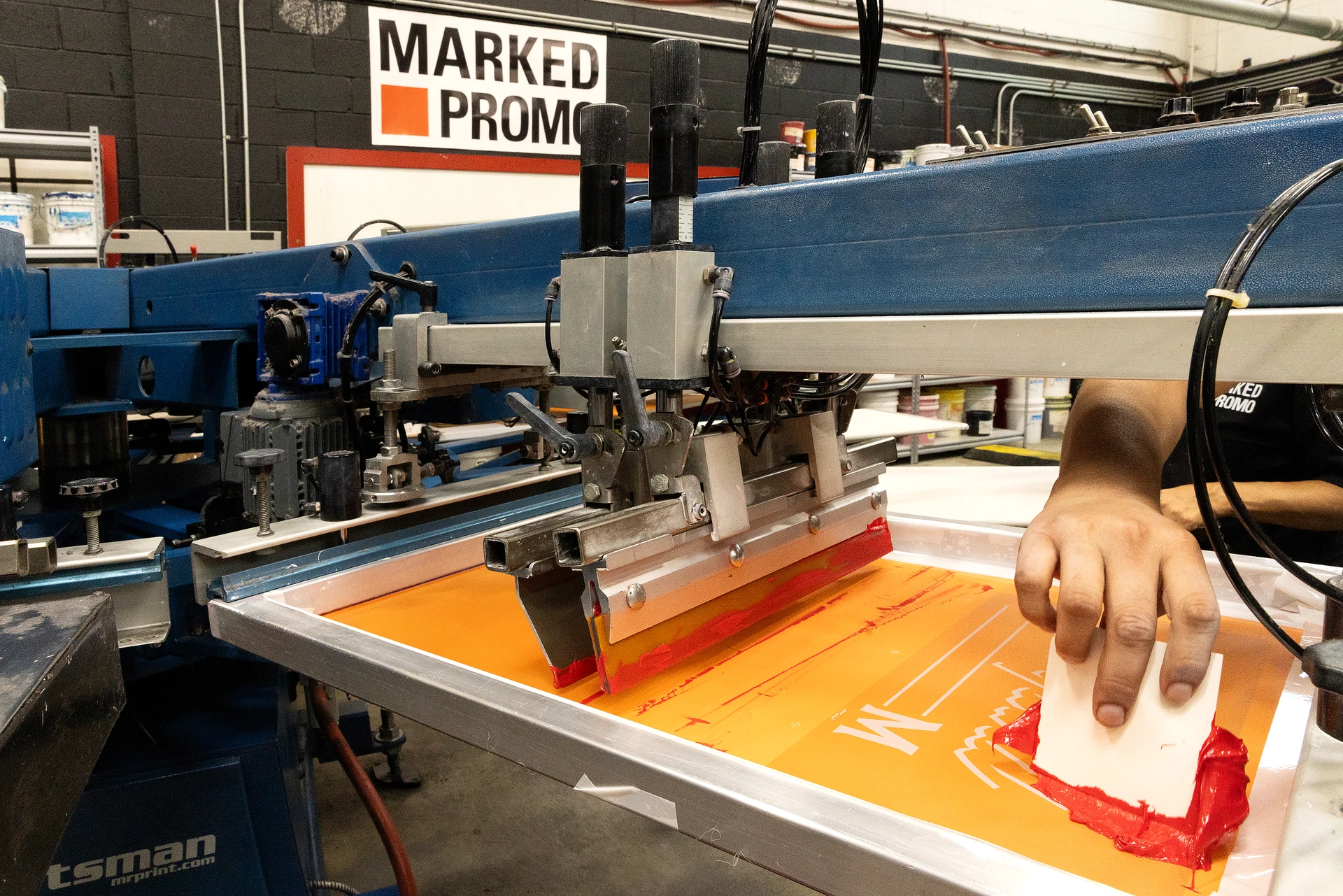 Marked Promo team screen printing a branded design in-house
