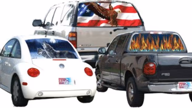Three vehicles with decorative rear window graphics: a white car with a shattered glass design, a black pickup truck with flames, and an SUV with an American flag and eagle.