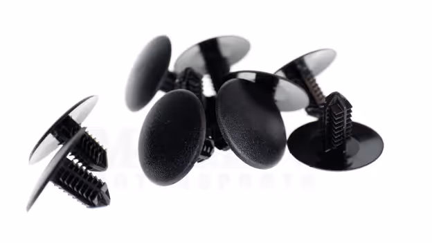 Group of black plastic push-in hood insulation retainers with flat round heads on a white background.