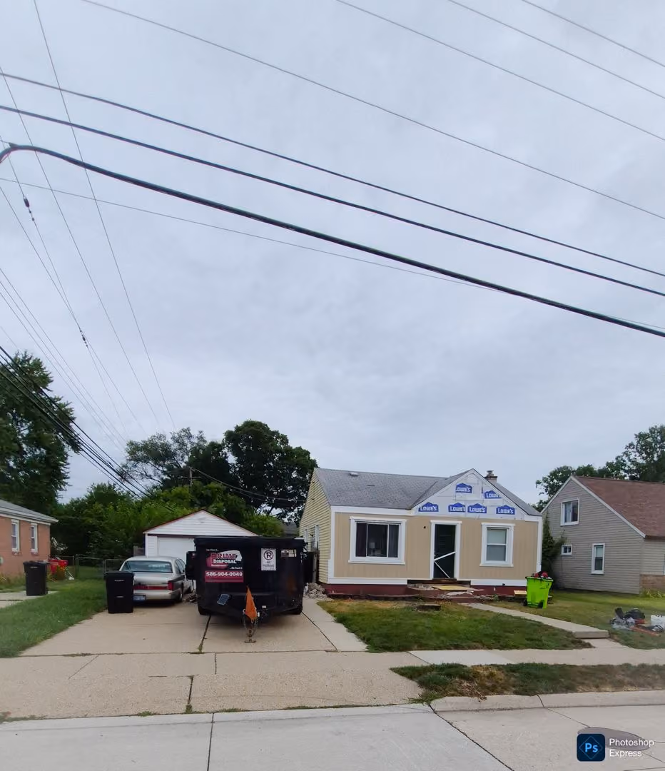 Residential driveway with a black dumpster rental for a clutter free home project in royal oak mi