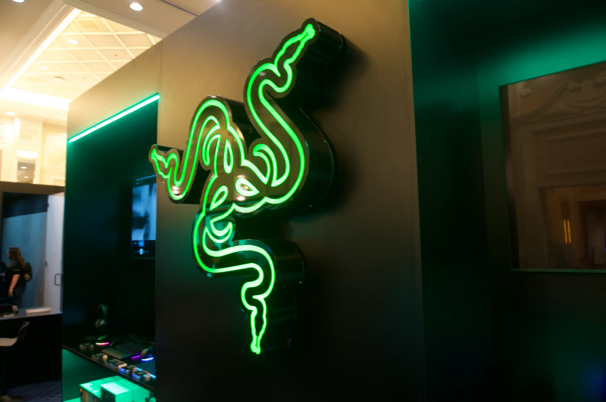 Illuminated 3D Razer brand signage with signature green glow, showcasing premium environmental branding and custom lighting for a high-end tech showcase.