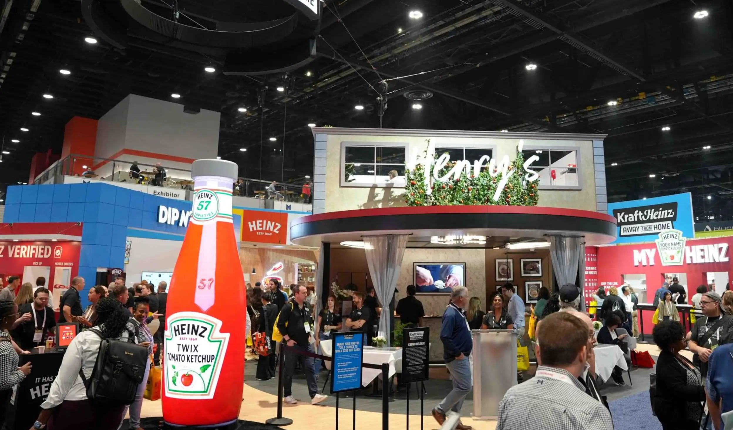 The Kraft Heinz National Restaurant Association booth showcasing the 'Henry’s' restaurant facade, utilizing bold brand-red structural beams, sophisticated lighting, and custom environmental graphics.