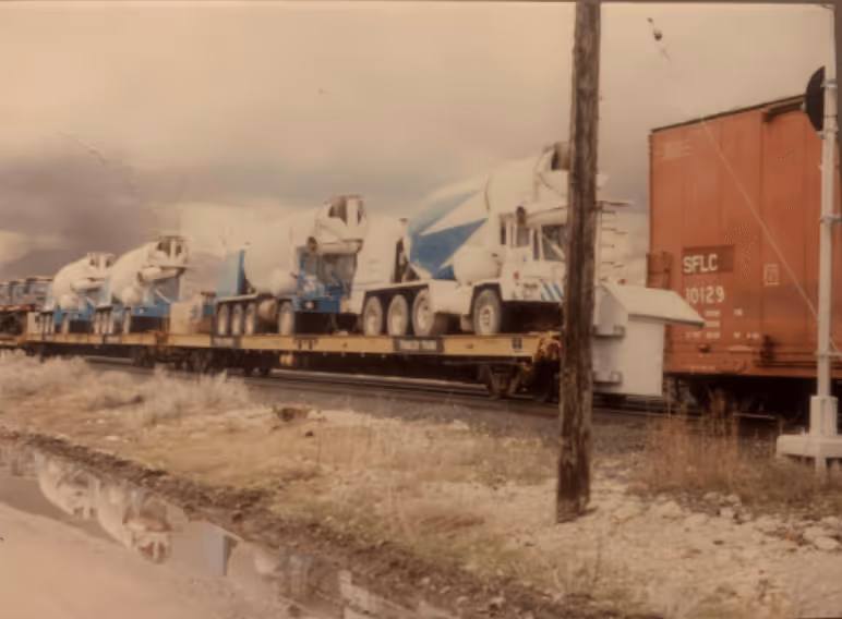 Old photo with concrete trucks on a train.