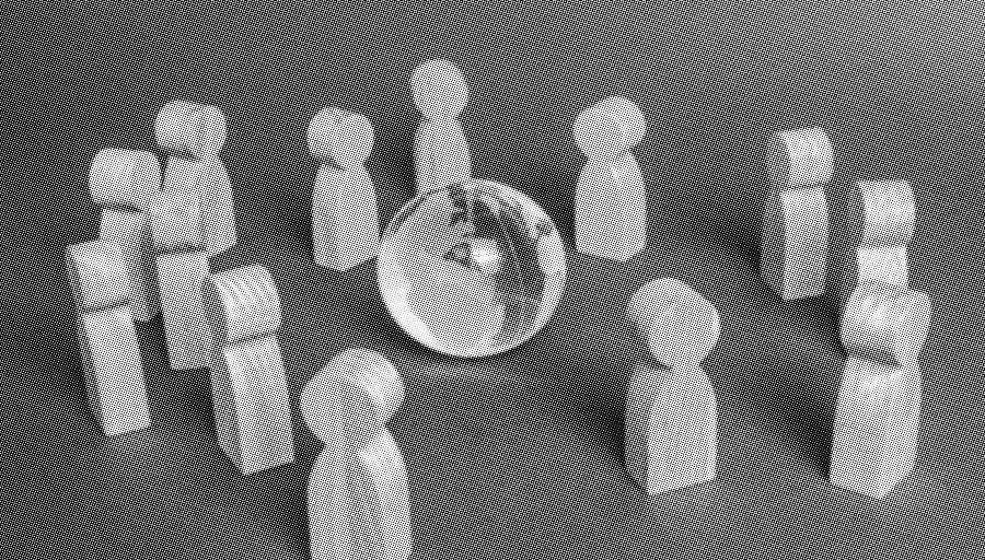 grayscale halftone image of wooden people figures surrounding a glass globe on a plain backdrop