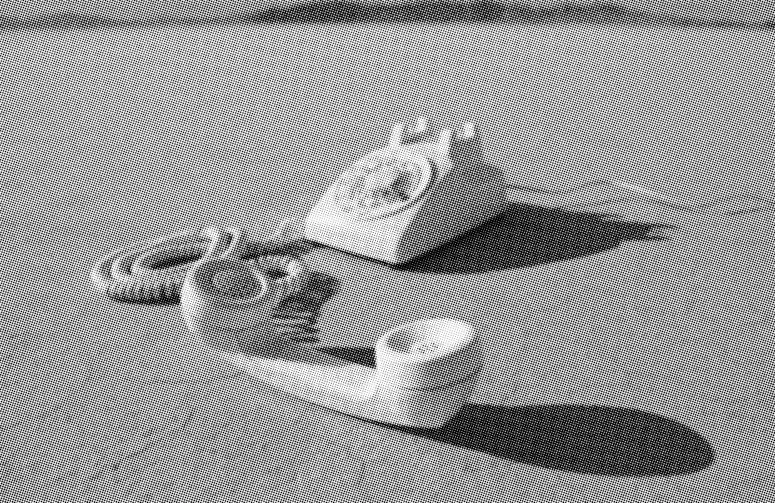 grayscale halftone image of a rotary phone on the dried up floor of a desert dry lake bed cracked dirt ground