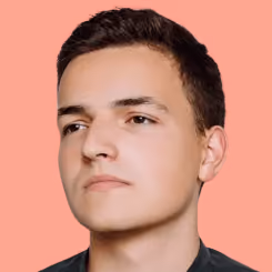Young man with short dark hair looking slightly left on a peach background.