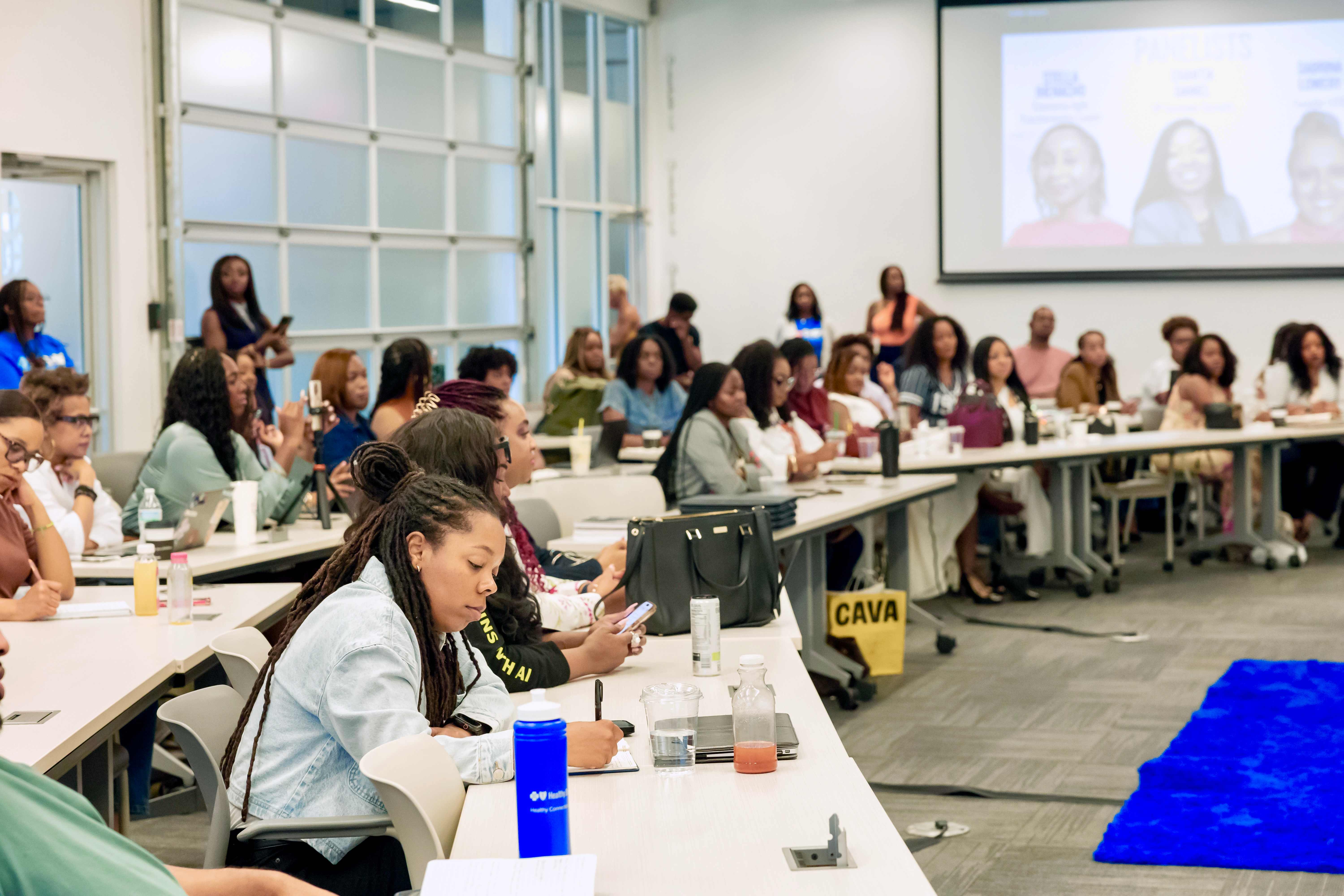 A group of women at desk learning at a conference