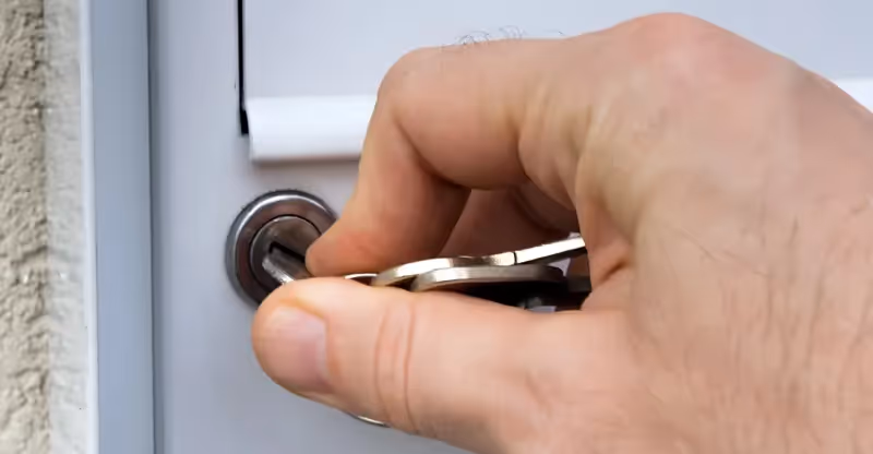 Hand inserting key into mailbox lock for repair or replacement in Dubai