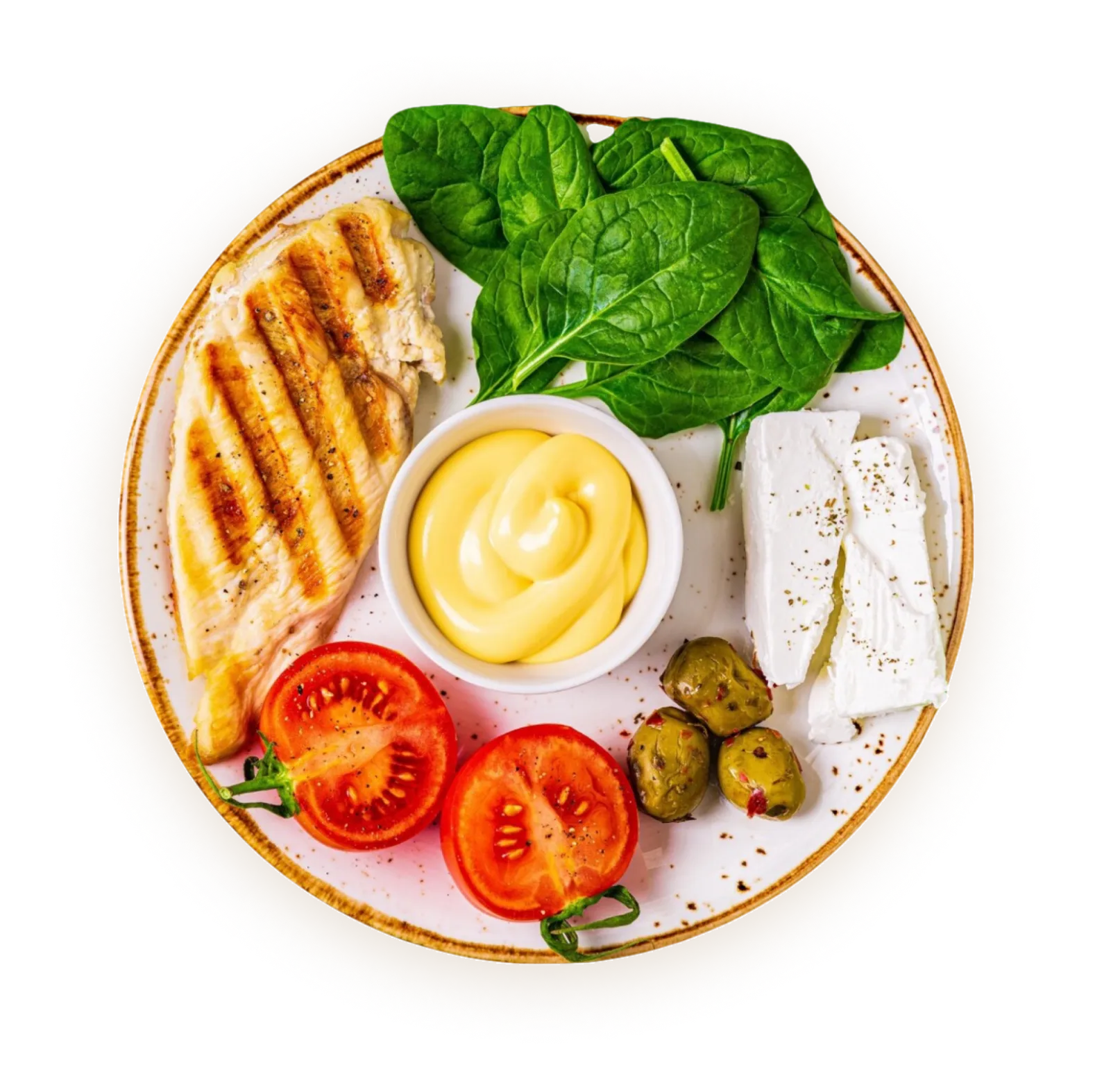 Plate with grilled chicken breast, fresh spinach, sliced tomatoes, green olives, two slices of white cheese, and a small bowl of yellow sauce.