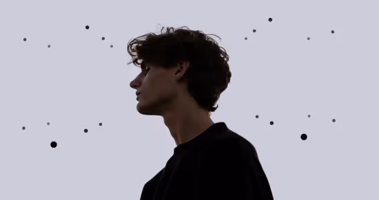 Silhouette of a young man with curly hair looking to the left against a plain gray background with scattered small black dots resembling stars.