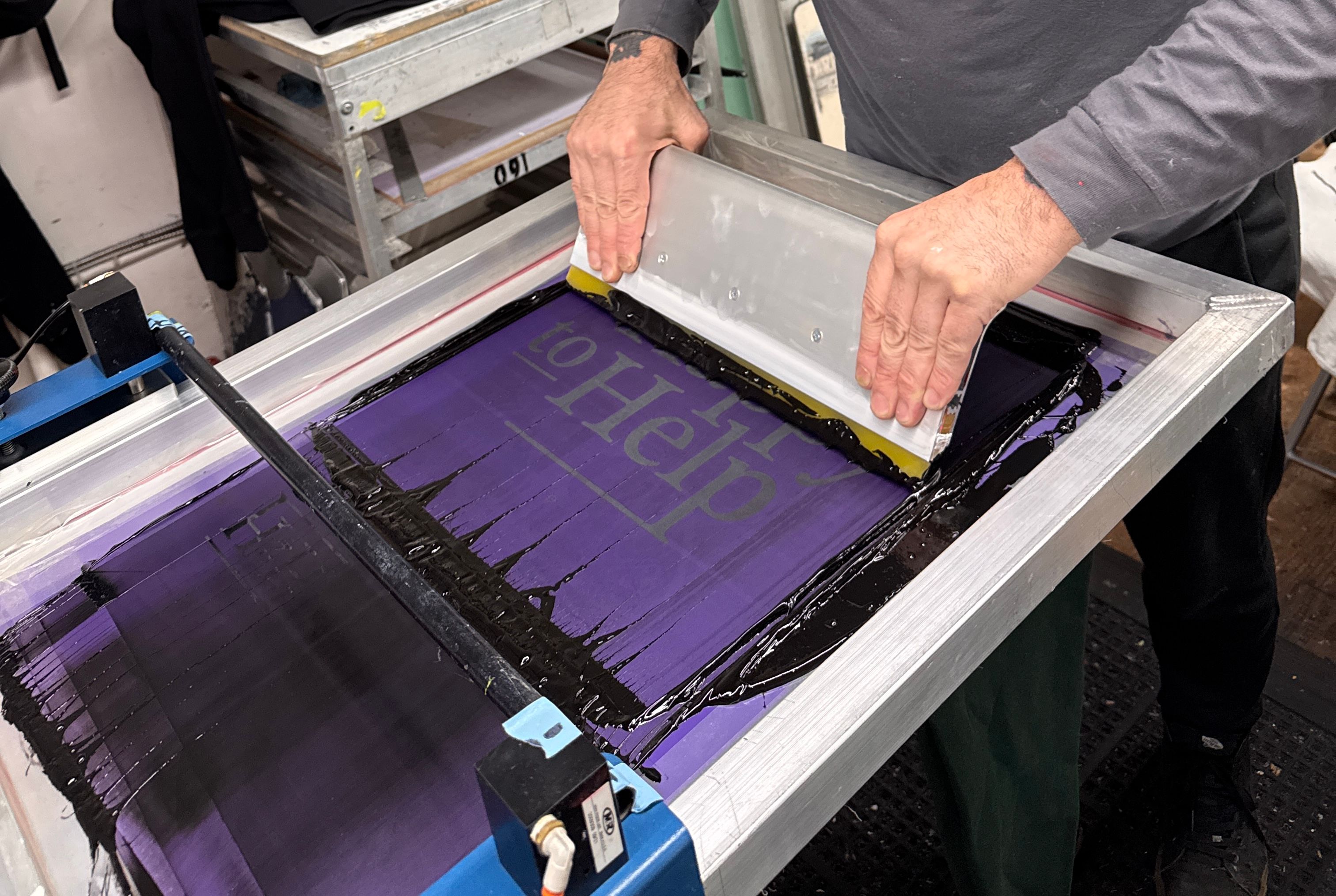 An image of our screen printer printing on the manual screen print machine