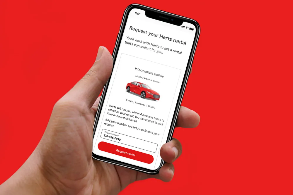 Hand holding smartphone showing Hertz rental request screen with red car and phone number input field.