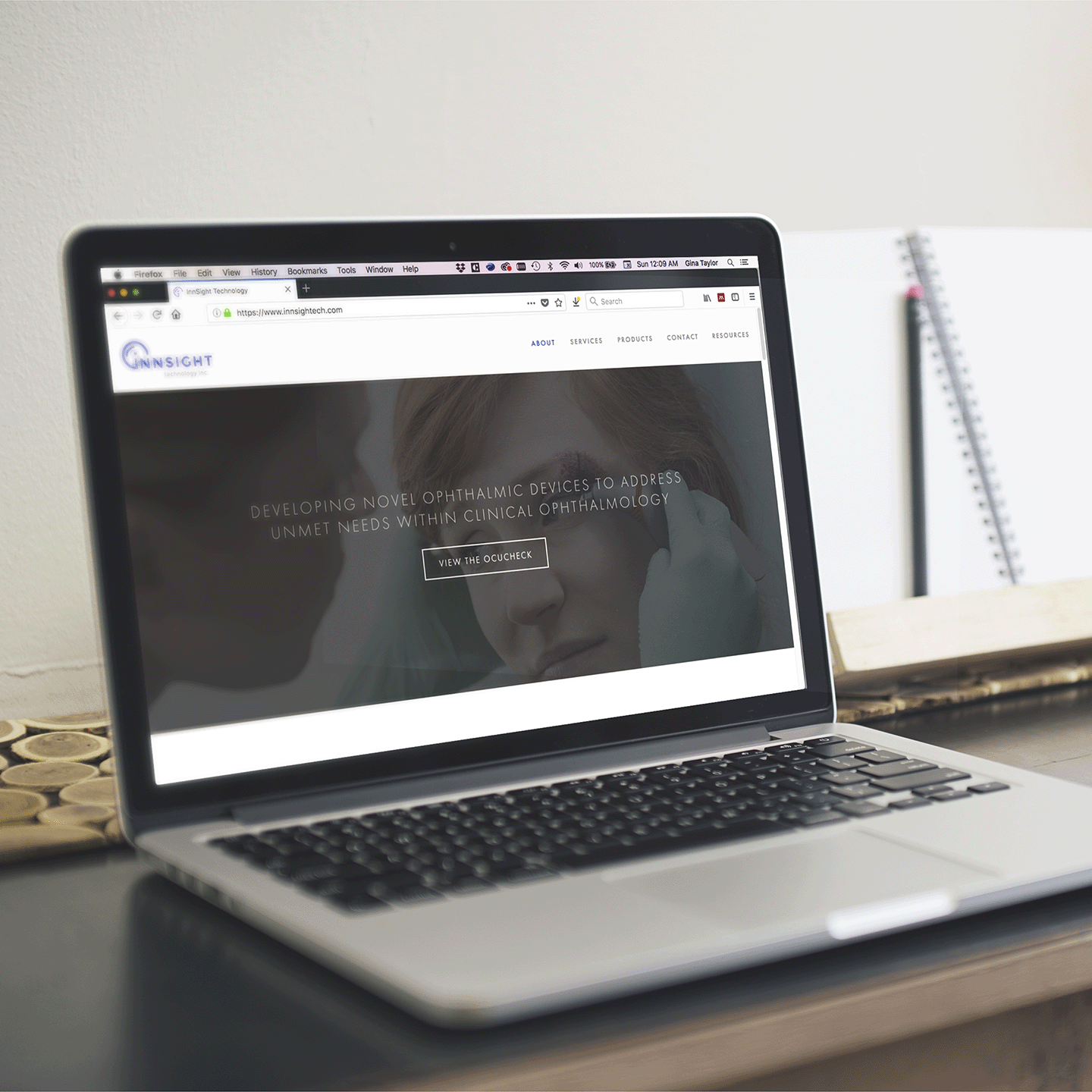 Laptop displaying InnSight Technology's website homepage with slogan about developing novel ophthalmic devices and a button labeled View the OcuCheck.