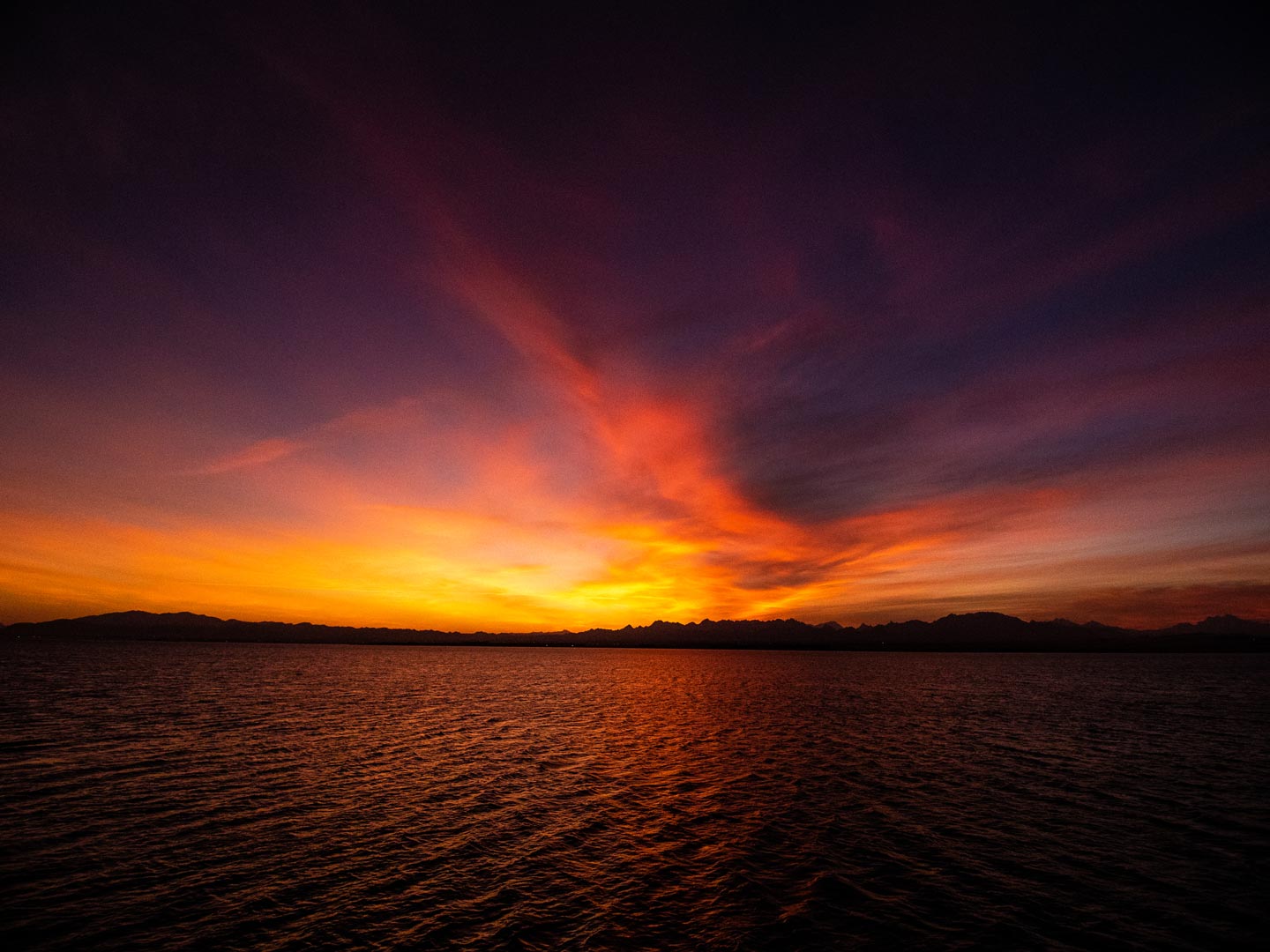 Intensives Abendrot über dem Steg von Somabay. Die kraftvolle Farbstimmung visualisiert das Ziel der Retreats von Alexander Neubert: Alltagsgrau in lebendige Klarheit und neue Energie für das Future-Me zu verwandeln.