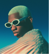 Person wearing a wide-brimmed white hat and a black outfit holding a large white abstract sculpture with a hole in the center.