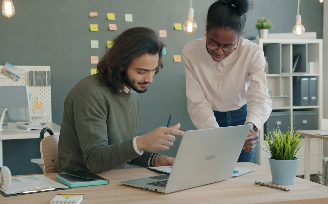 Two colleagues working through numbers on a laptop