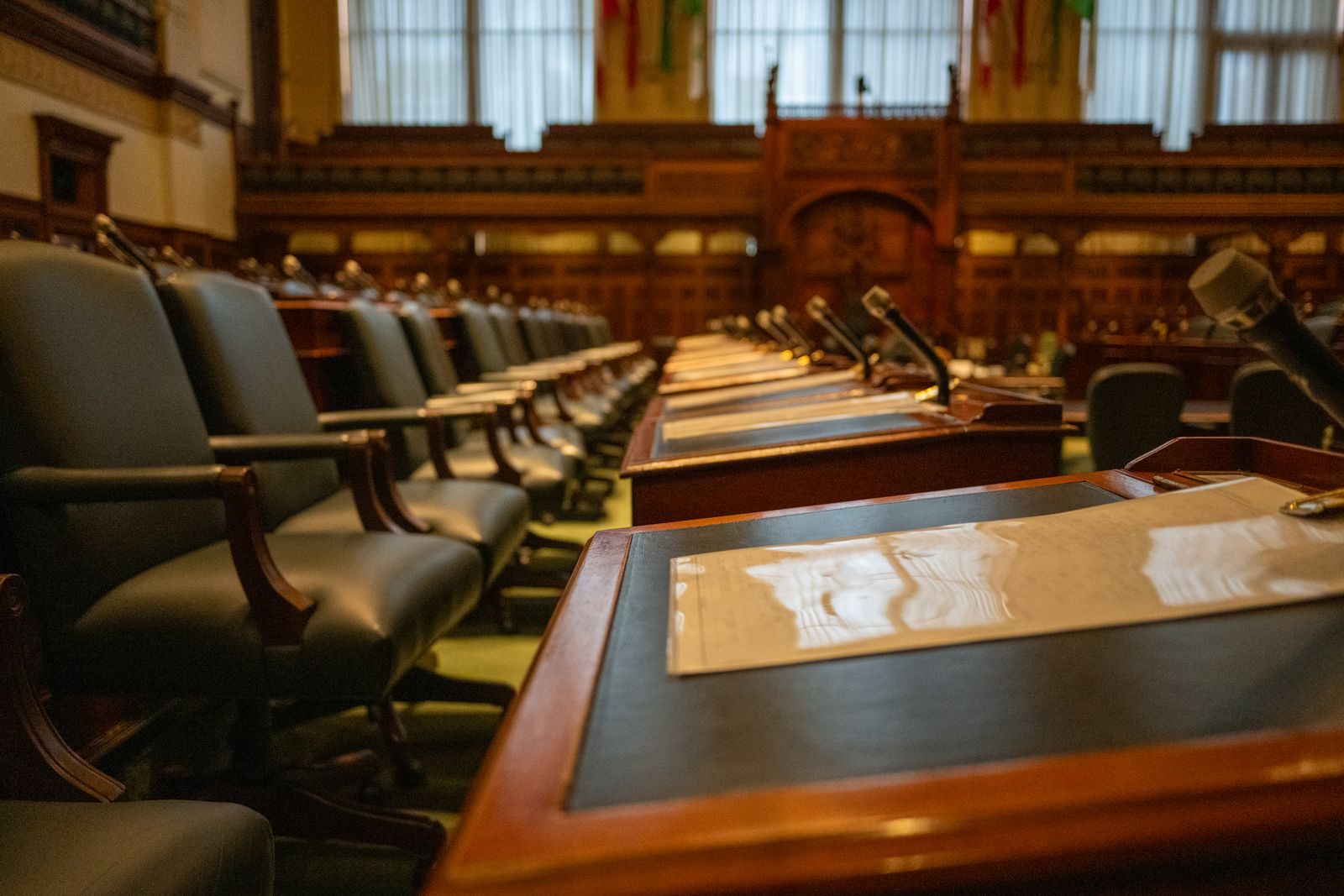 Pupitres et micros d'une assemblée parlementaire avant une séance de vote