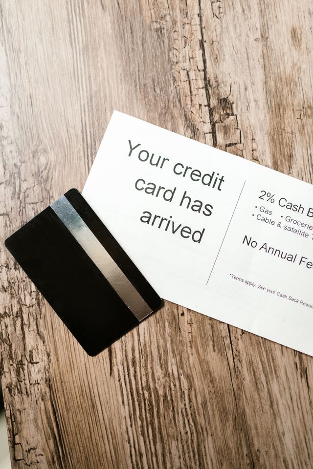 Carte bancaire noire posée sur un courrier annonçant l'arrivée d'une carte de crédit