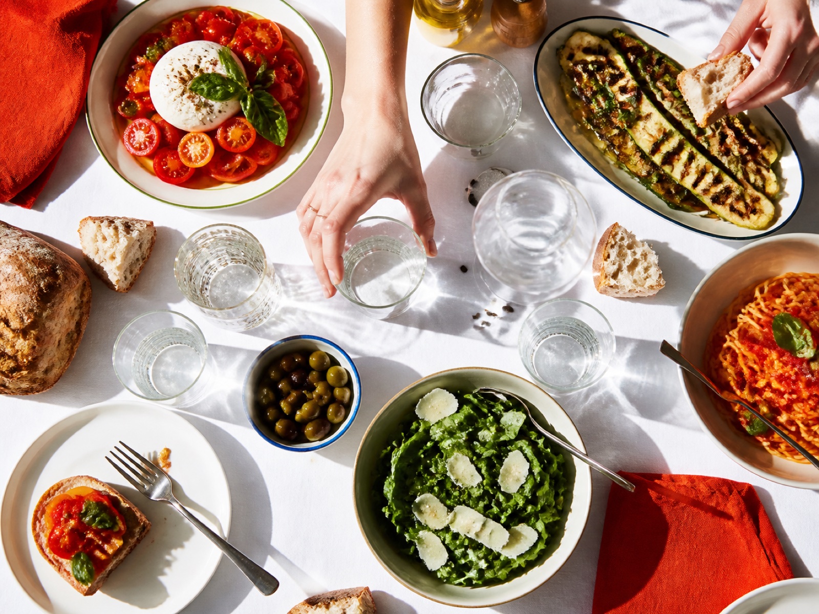 Generous sunlit lunch shared on a white table