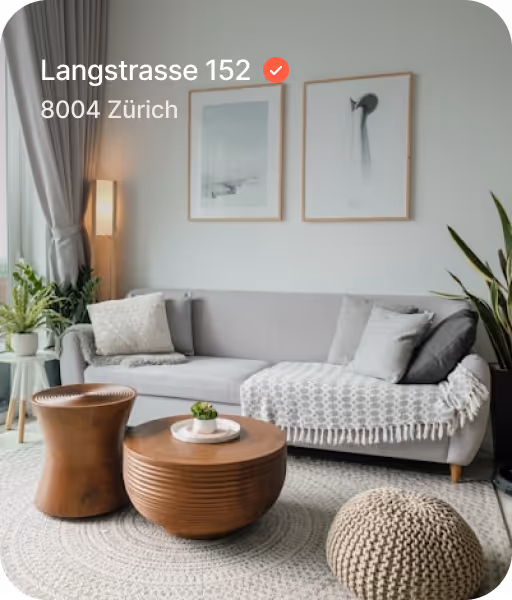 Modern living room with a grey sofa, wooden coffee tables, knitted pouf, houseplants, framed wall art, and a floor lamp near curtained window.