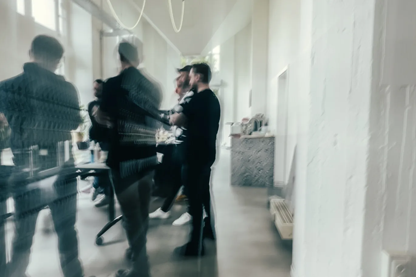Eine Gruppe von Menschen in einem hellen, modernen Raum, unscharf und verschwommen durch Bewegung.
