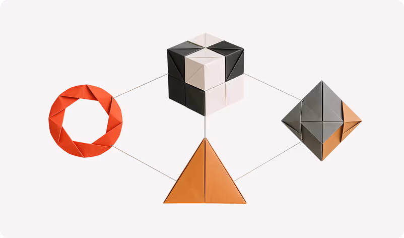 Abstract interconnected geometric shapes made of folded paper: a red ring, a black-and-white cube, a brown triangle, and a gray diamond on a white background.
