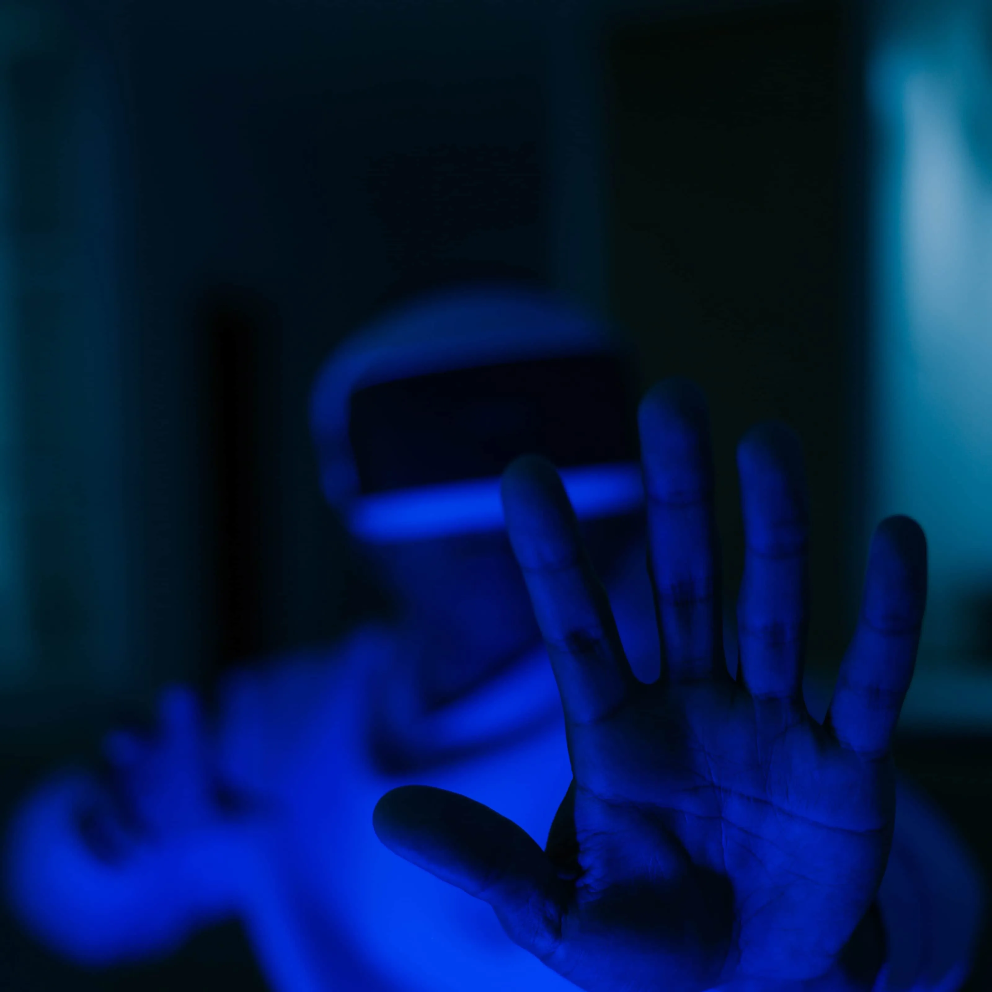 A person's hand in blue light