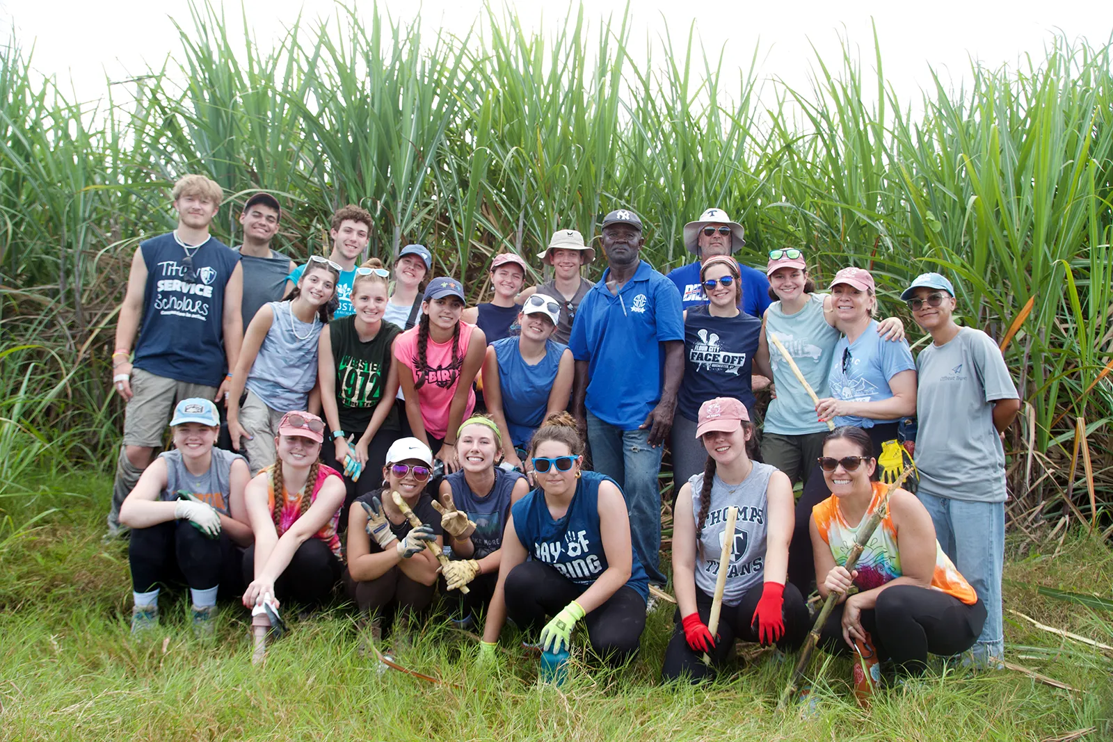 A large group of students standing together in a sugar cane field in the Dominican Republic