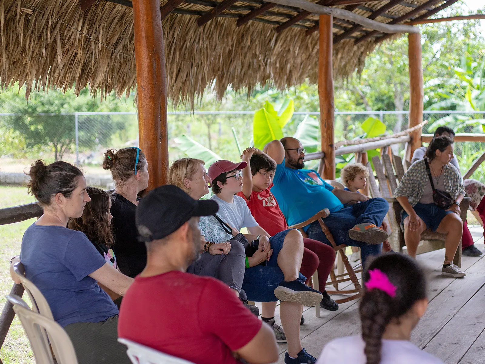 Travelers seated under an open-air thatched shelter during a program in the Dominican Republic
