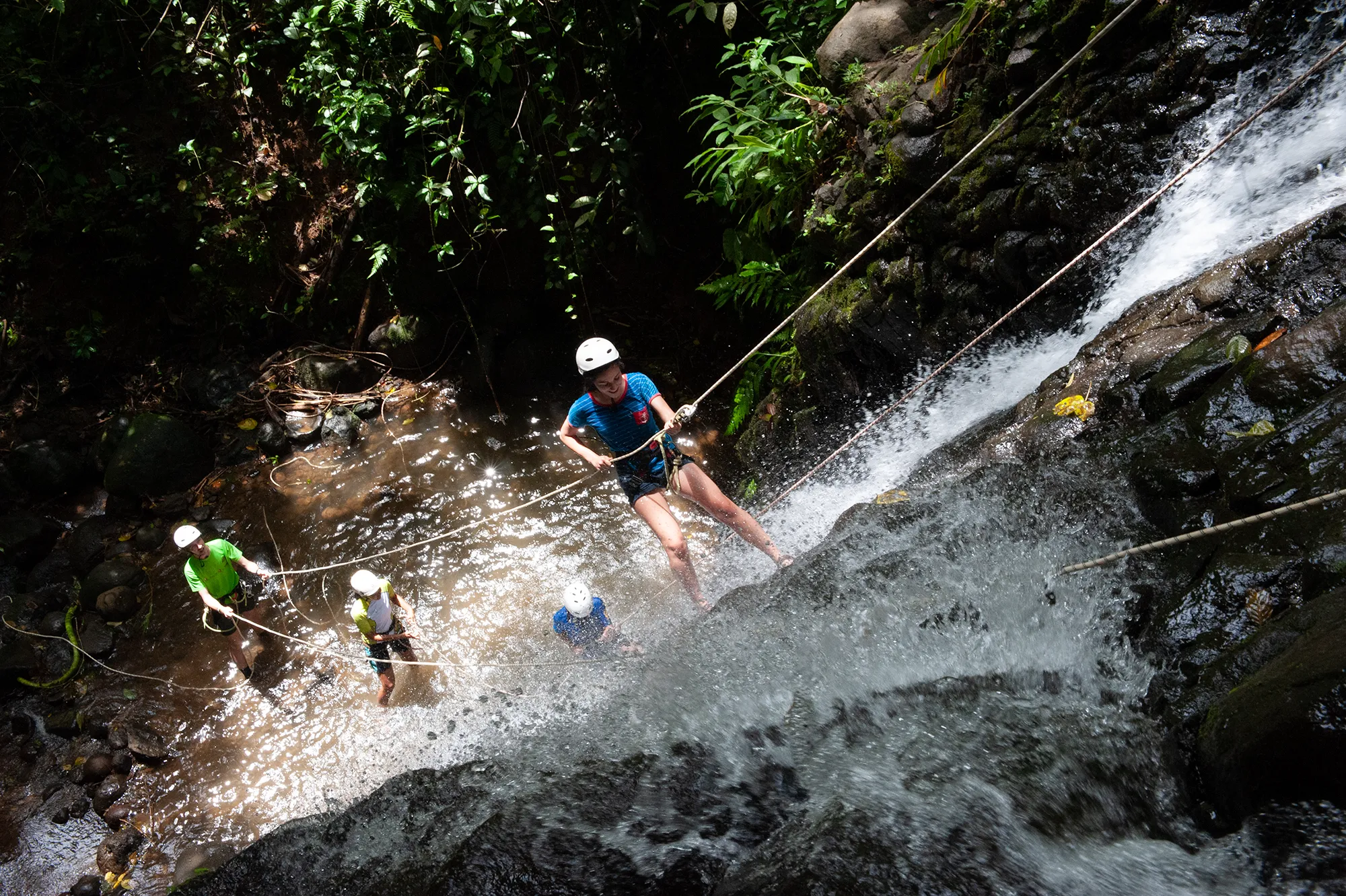People rappelling down a waterfall while canyoning in Costa Rica