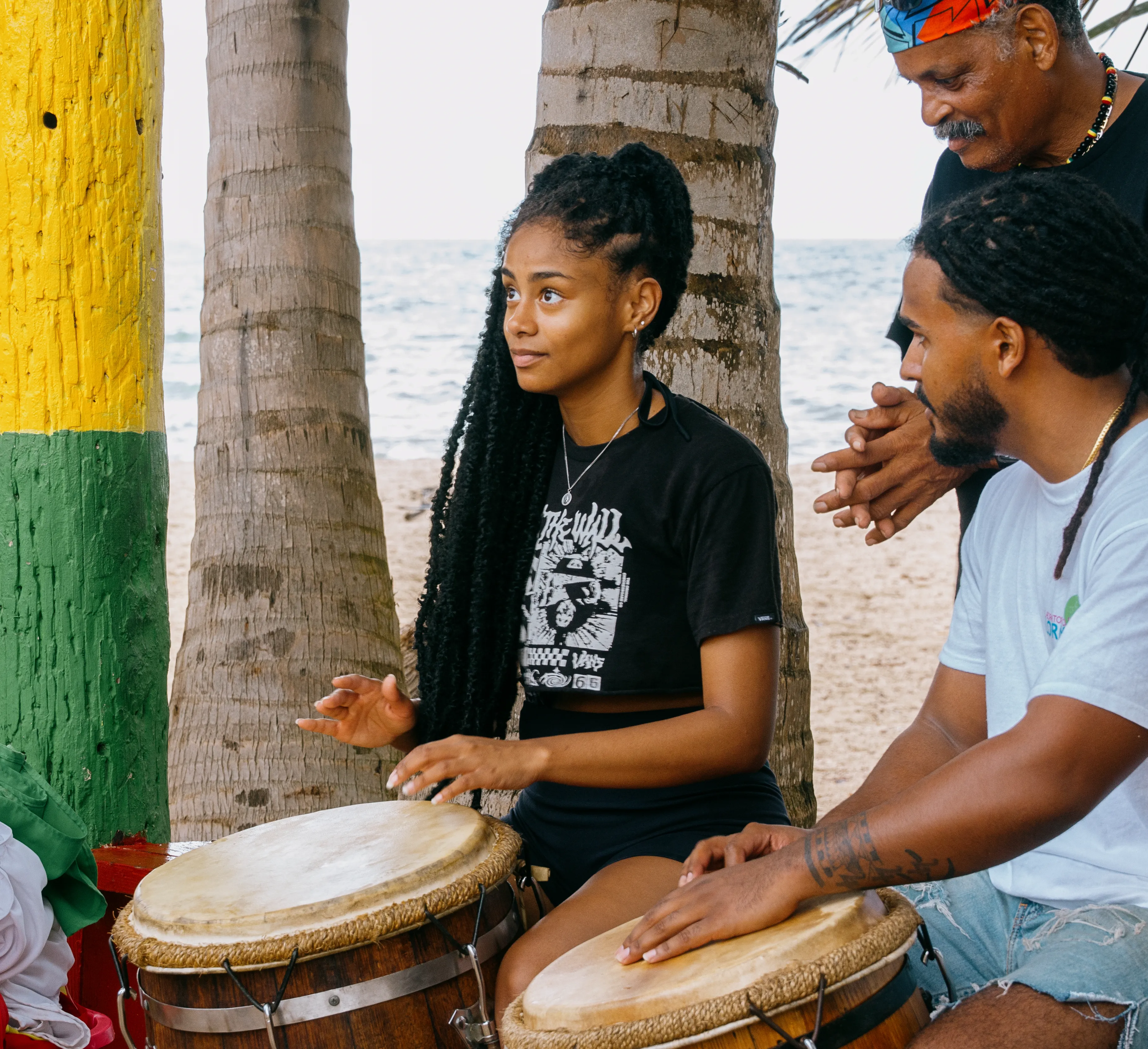 Two people beside a palm tree painted with colorful bands in Puerto Rico