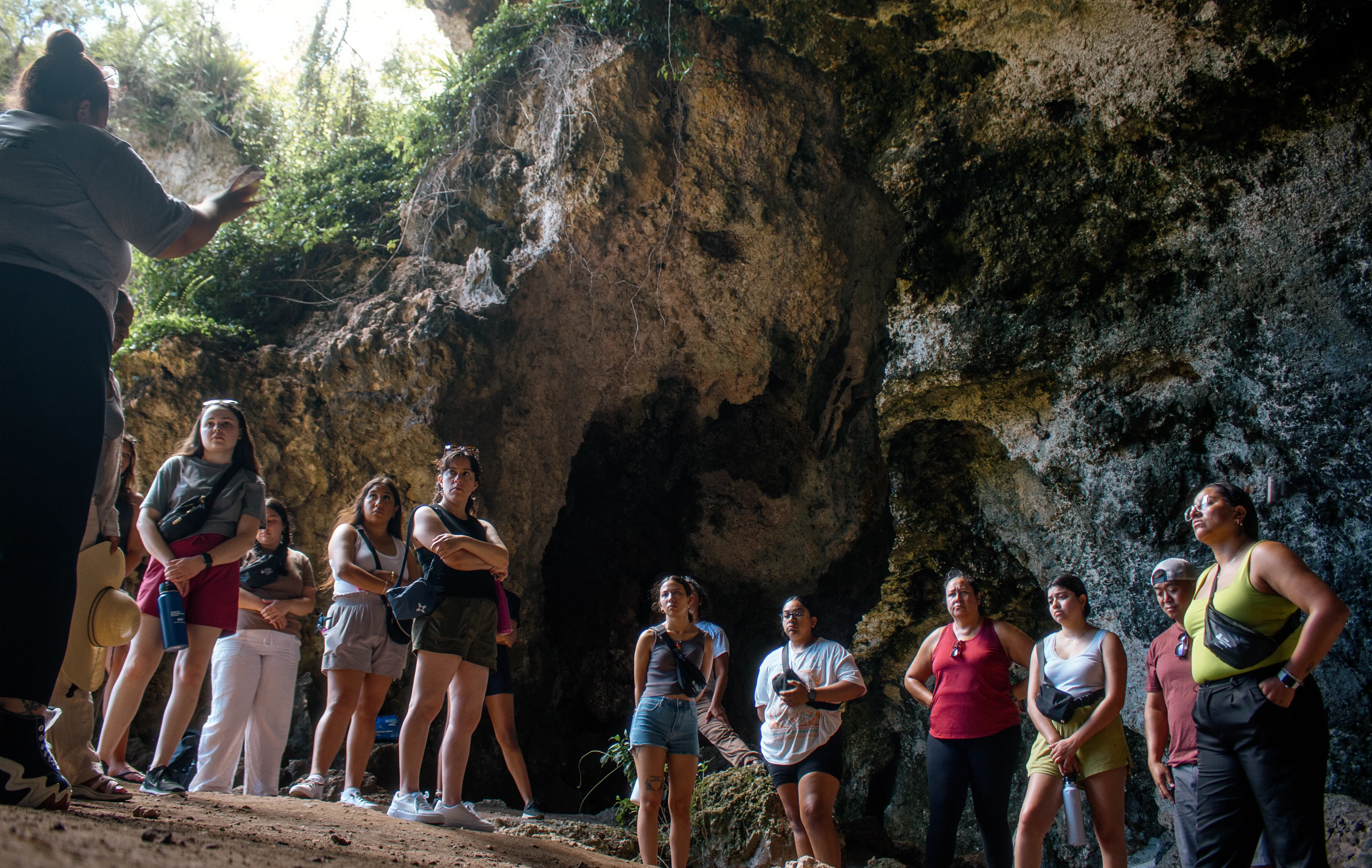 A group of travelers gathered among coastal rock formations in Puerto Rico