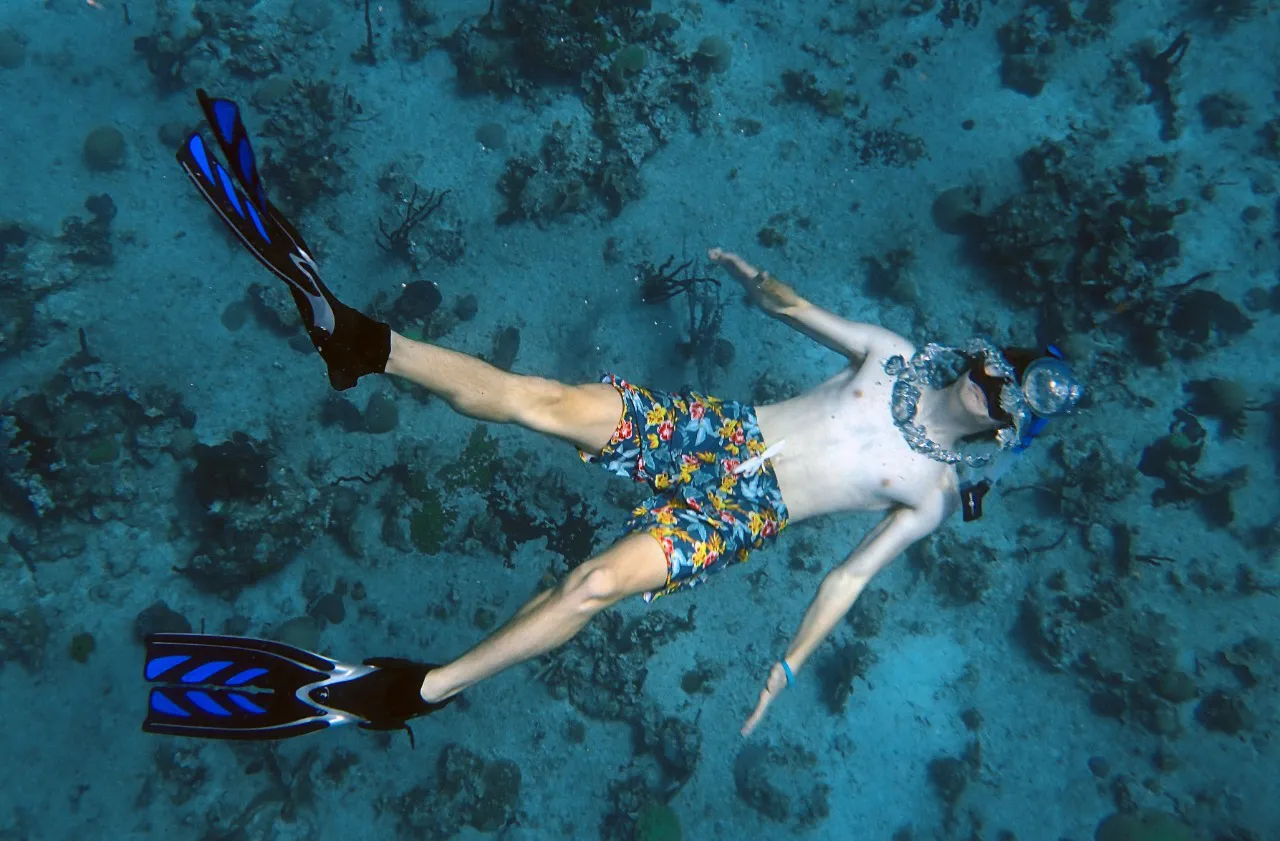 Two snorkelers exploring a coral reef in clear turquoise water in the Dominican Republic
