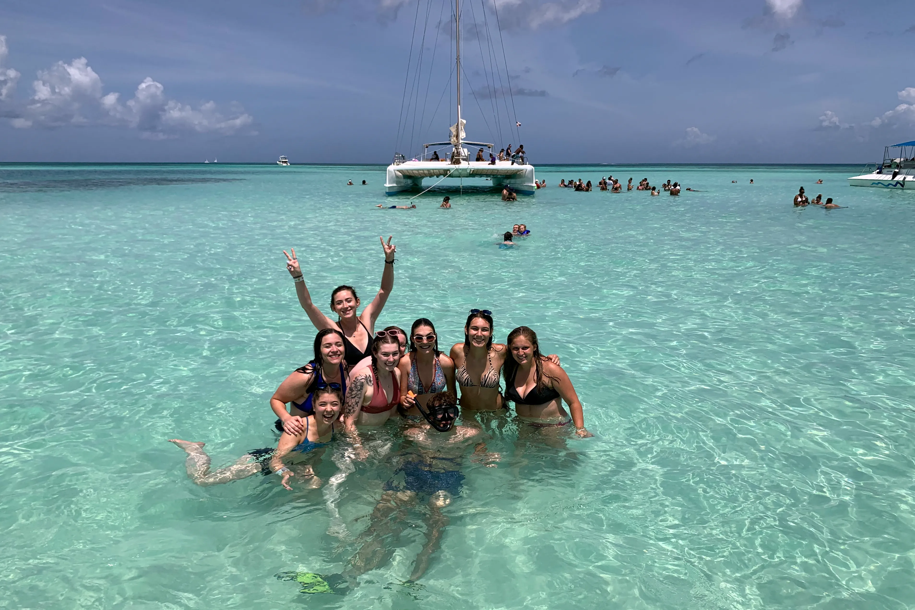 A group of young travelers posing together in turquoise water in the Dominican Republic