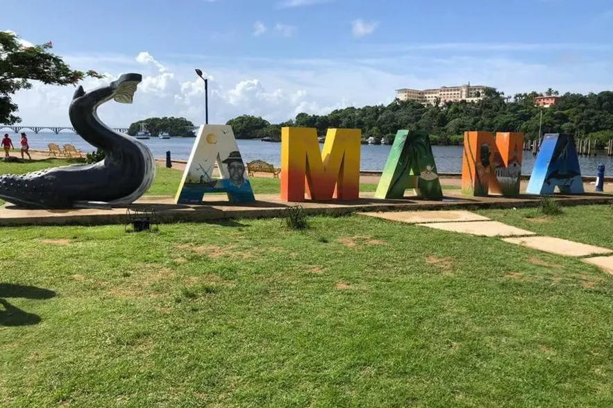 Colorful “Samána” letter sculptures on a lawn by the waterfront in the Dominican Republic