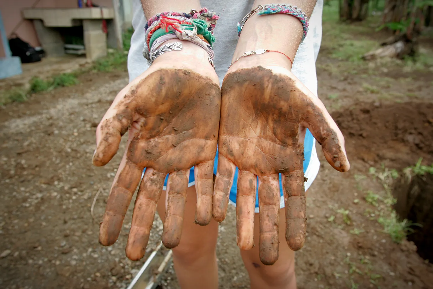 A student's mud-covered hands after planting trees in Costa Rica