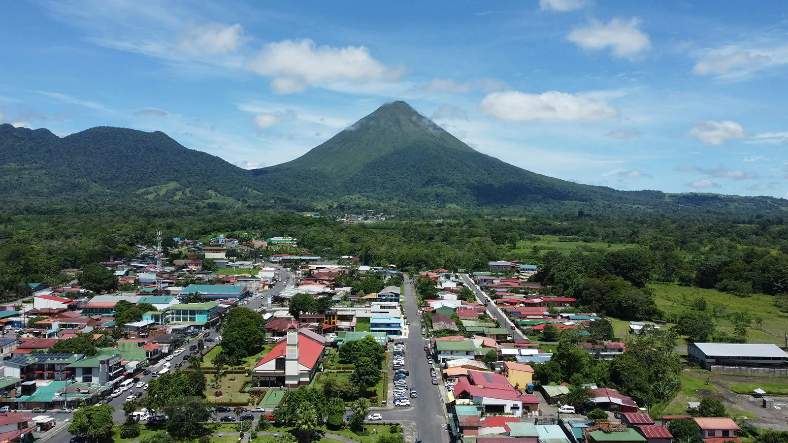 A view over a small town with Arenal Volcano rising behind it in Costa Rica
