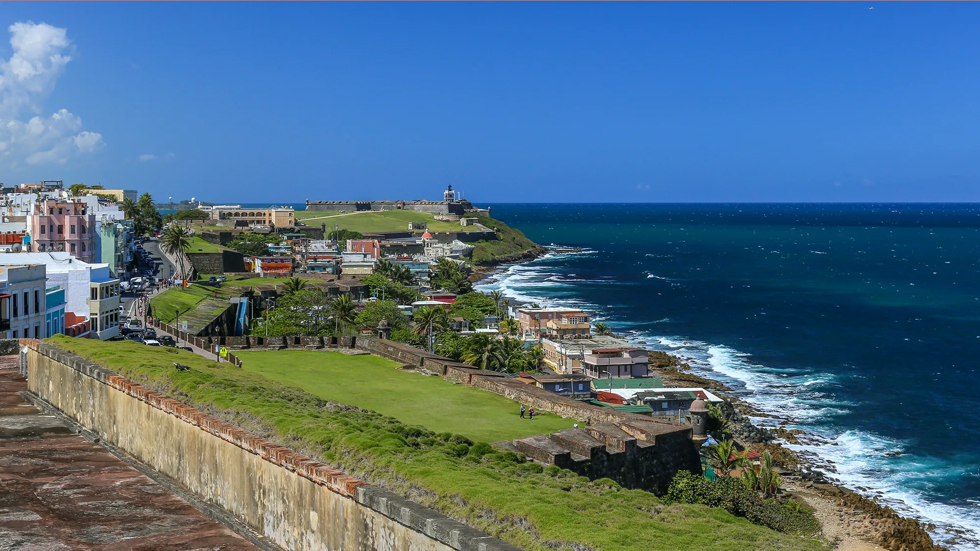 An aerial view of Old San Juan's colorful buildings and historic fort along the coast in Puerto Rico