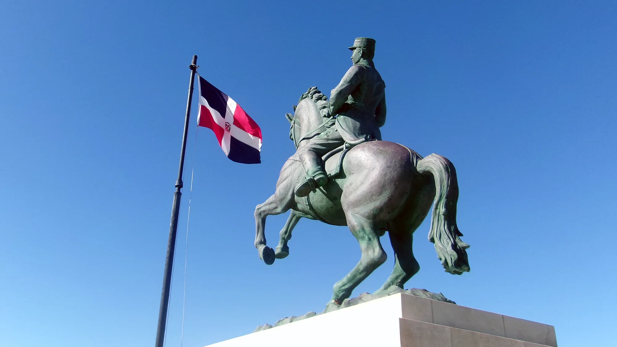 An equestrian statue with the Dominican flag flying behind it in the Dominican Republic